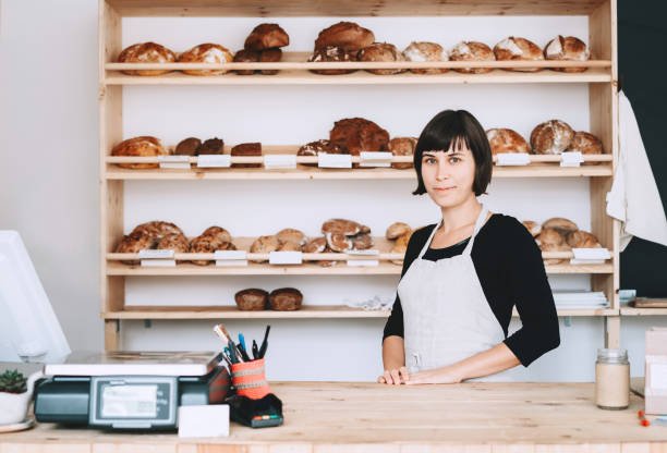 istock Female bakery worker behind the counter ready to service. 1190360679