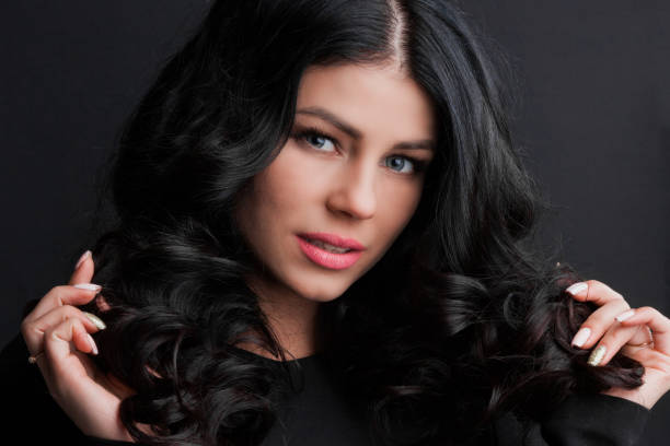 istock Brunette woman touching curly hair 1190360758