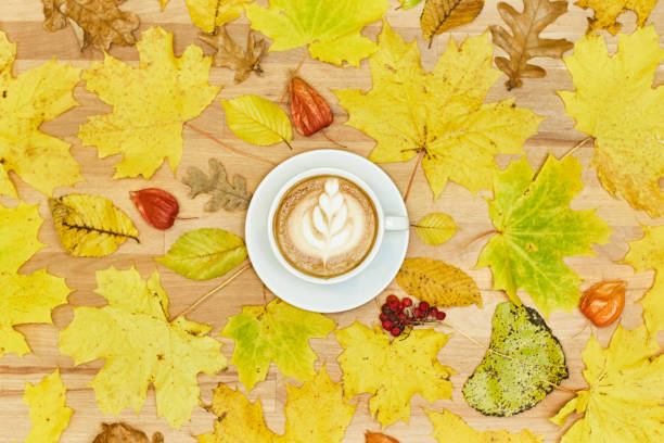 istock Autumn flat lay composition with dry leaves wreath frame and coffee latte cup on wooden background. 1190362859