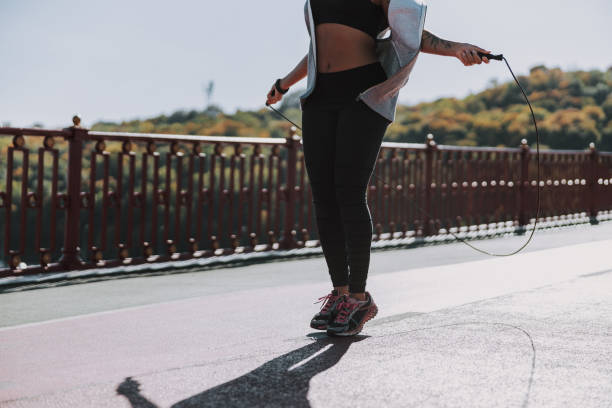 istock Athletic Afro American lady jumping over skipping rope 1190363402
