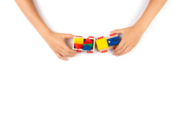istock Kid hands playing with toy train on white table background. Top view 1190363508