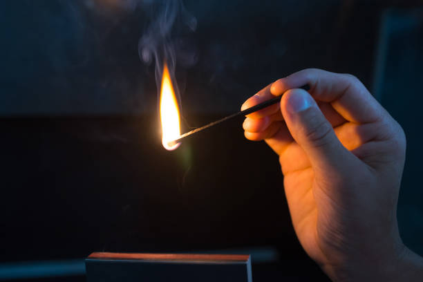 istock A Match ignited by rubbing the match head against a match box. Hand with burning match 1190367009