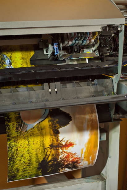 istock Old broken printer in workshop. The concept of cleaning and calibrating printers. Sunset, tent and green grass in the photo. Picturesque nature photo printed on printing equipment. 1190367298