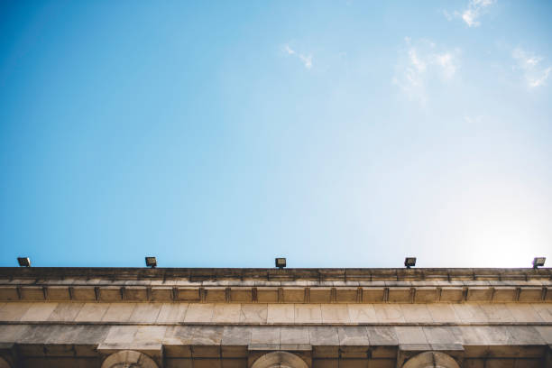 View from below of Neo-Classical university law building superstructure and blue sky in Buenos Aires.