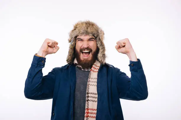 Photo of photo of amazed bearded man wearing winter clothes celebrate success