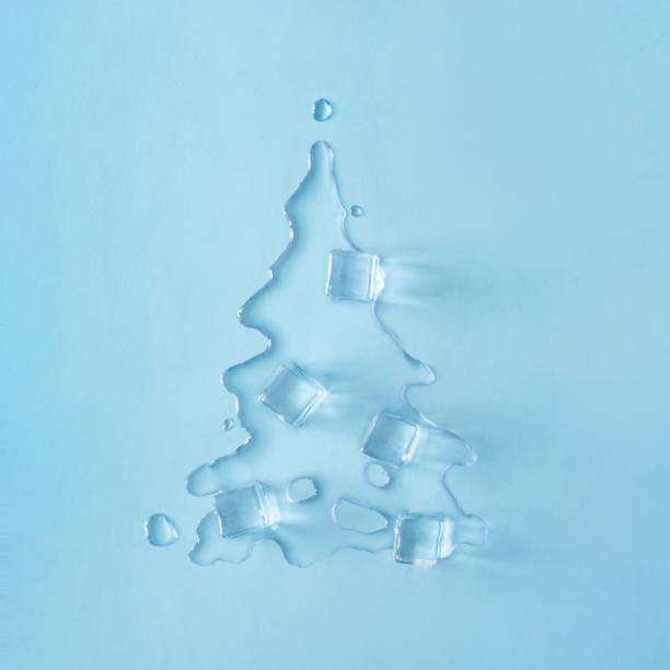 Christmas tree shape made with melting ice on bright blue background.