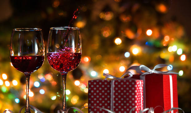 mooie splash van rode wijn op de achtergrond van kerstverlichting - wine christmas stockfoto's en -beelden