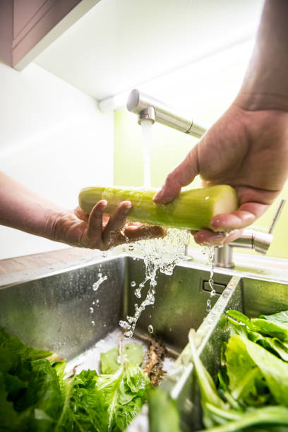istock Young Man Washing Vegetables For Salad 1190372401