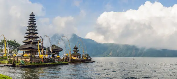 Photo of Pura Ulun Danu Bratan, Bali. Hindu temple surrounded by flowers on Bratan lake, Bali. Major Shivaite water temple in Bali, Indonesia. Hindu temple