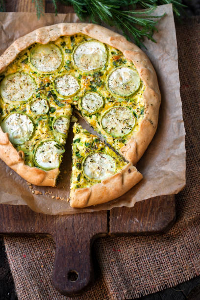 istock Homemade courgette and goat cheese pie on a dark rustic wooden board background 1190375344