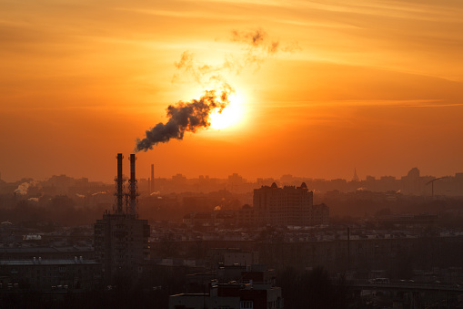 Air pollution smoke from pipes and factory with sunset background