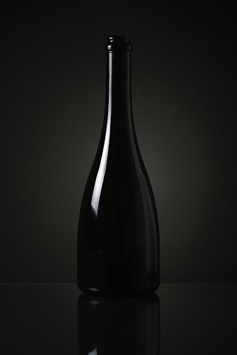 Elegant glass wine bottle on black background.
