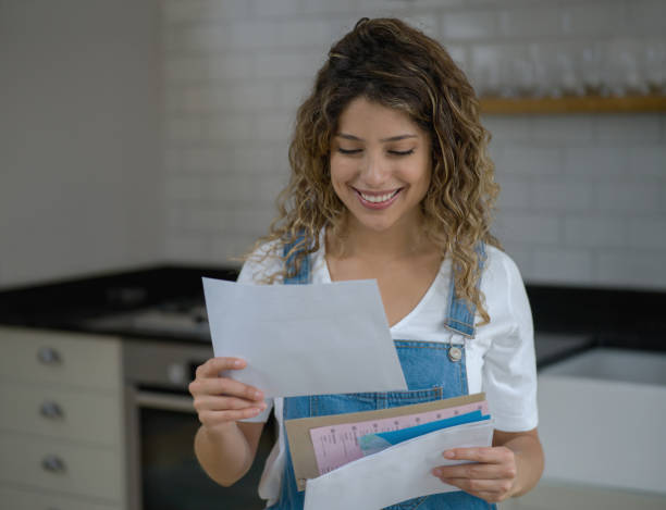 young beautiful woman at home checking her mail looking very happy - opening mail letter envelope imagens e fotografias de stock