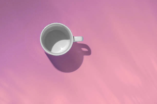 istock Empty tea cup on pink paper background. Coffee mug from above. Minimal concept Hard deep shadow. Flat lay, top view. 1190377792
