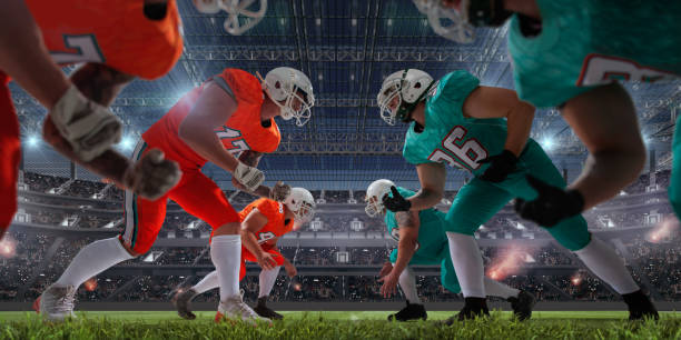 AMERICAN FOOTBALL. American football players in professional sport stadium. football field night american culture empty stock pictures, royalty-free photos & images