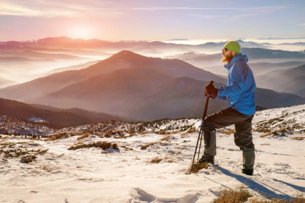istock Man hiking in beautiful winter mountain at sunset 1190380604