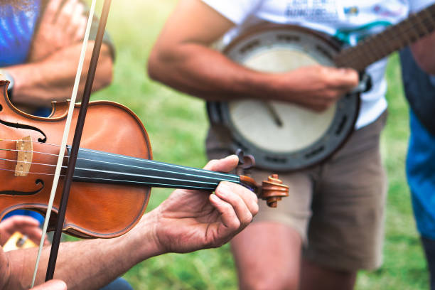 violín y banjo jugadoales al aire libre en una fiesta popular en el campo,jpg - violinista fotografías e imágenes de stock