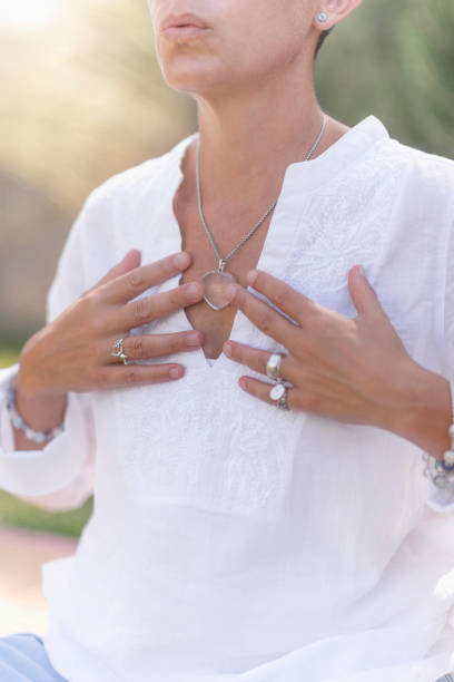 ehrlichkeit handgeste - spirituality hand on heart meditating women stock-fotos und bilder