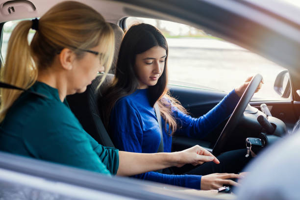 adolescente che ha una lezione di guida con istruttore femminile - driving test foto e immagini stock