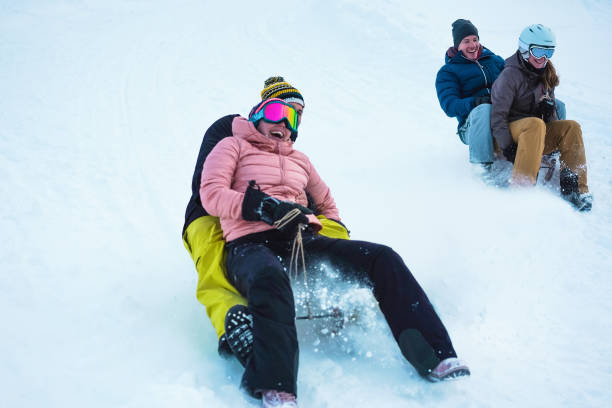 verrückte glückliche freunde mit spaß mit rodeln auf schnee hohen bergen - junge leute machen rodel-wettbewerb in der weißen woche urlaub - wintersport und reisekonzept - weiche fokus auf rechte mädchen gesicht - switzerland hotel skiing people stock-fotos und bilder