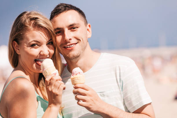 istock Man and woman eating ice cream on beach 1190387624