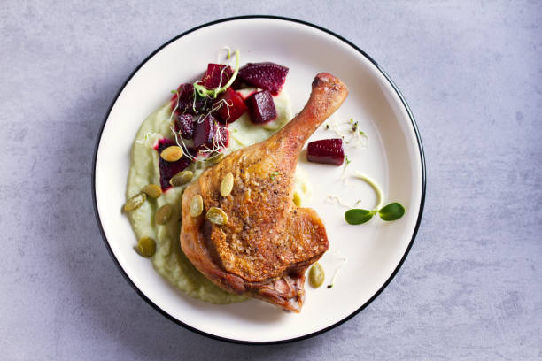 istock Roast duck leg with mashed green vegetables, beetroot, and pumpkin seeds on light gray background 1190387877