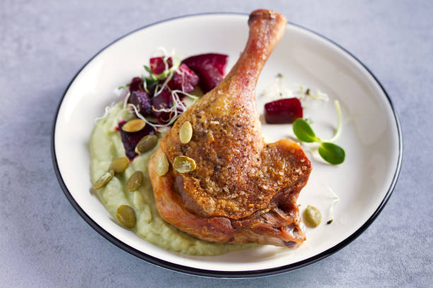 istock Roast duck leg with mashed green vegetables, beetroot, and pumpkin seeds on light gray background 1190387959