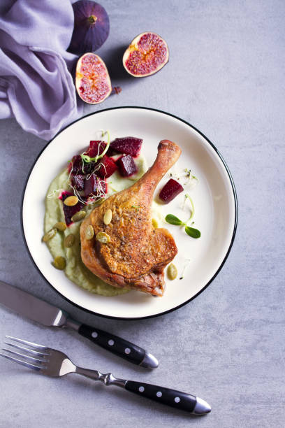 istock Roast duck leg with mashed green vegetables, beetroot, and pumpkin seeds on light gray background 1190388017