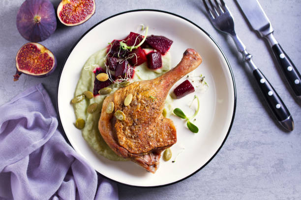 istock Roast duck leg with mashed green vegetables, beetroot, and pumpkin seeds on light gray background 1190388052