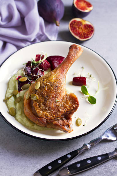 istock Roast duck leg with mashed green vegetables, beetroot, and pumpkin seeds on light gray background 1190388100