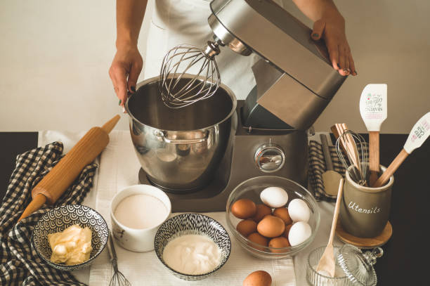 Confectioner girl is preparing a cake. Concept ingredients for cooking flour products or dessert Confectioner girl is preparing a cake. Concept ingredients for cooking flour products or dessert. Rural or rustic style. electric mixer photos stock pictures, royalty-free photos & images