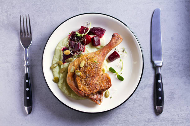 istock Roast duck leg with mashed green vegetables, beetroot, and pumpkin seeds on light gray background 1190388254