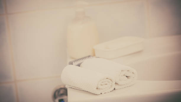 istock Two towels, soap in bottle with pump on sink 1190388422
