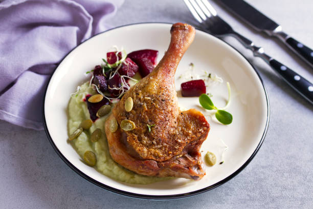 istock Roast duck leg with mashed green vegetables, beetroot, and pumpkin seeds on light gray background 1190388558