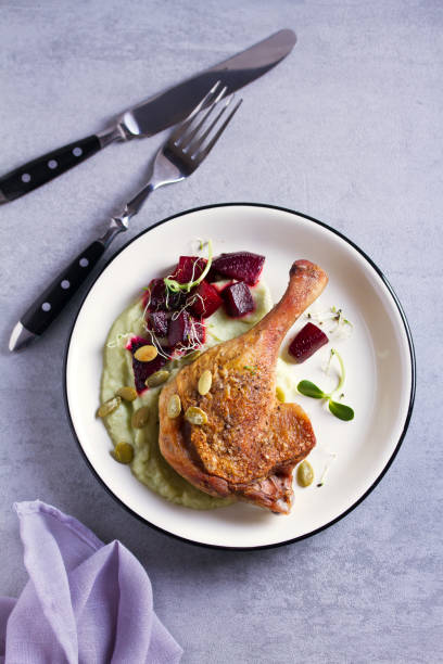 istock Roast duck leg with mashed green vegetables, beetroot, and pumpkin seeds on light gray background 1190388772