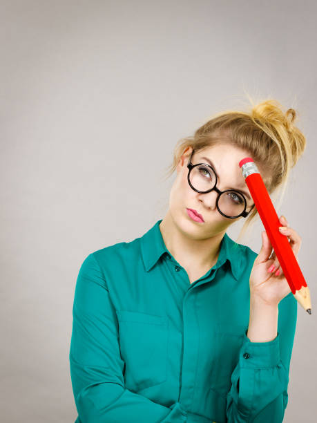 istock Woman confused thinking, big pencil in hand 1190388968