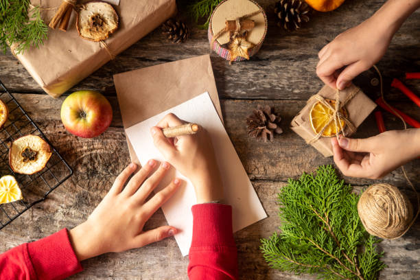 istock kids making Christmas decorations. Zero waste and eco friendly christmas concept with gift, branches and tdry fruit on rustic wooden background, copy space, top view, 1190390315