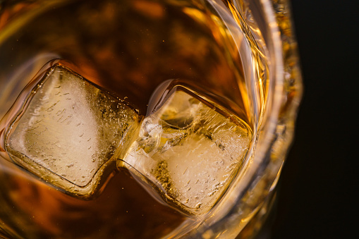 Glass of whiskey on dark table