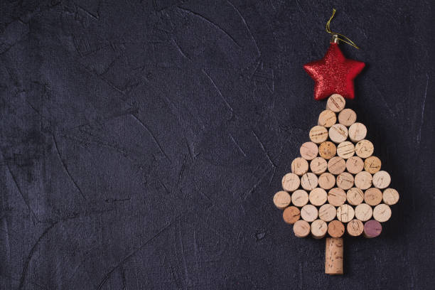 istock Christmas tree made of  wine corks on black background. Layout, flat lay, template. 1190390586