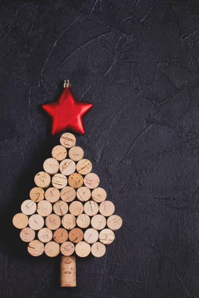 istock Christmas tree made of  wine corks on black background. Layout, flat lay, template. 1190390687