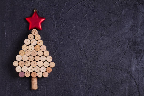 istock Christmas tree made of  wine corks on black background. Layout, flat lay, template. 1190390864