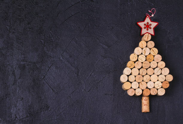 istock Christmas tree made of  wine corks on black background. Layout, flat lay, template. 1190390890