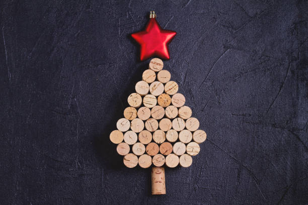 istock Christmas tree made of  wine corks on black background. Layout, flat lay, template. 1190390953