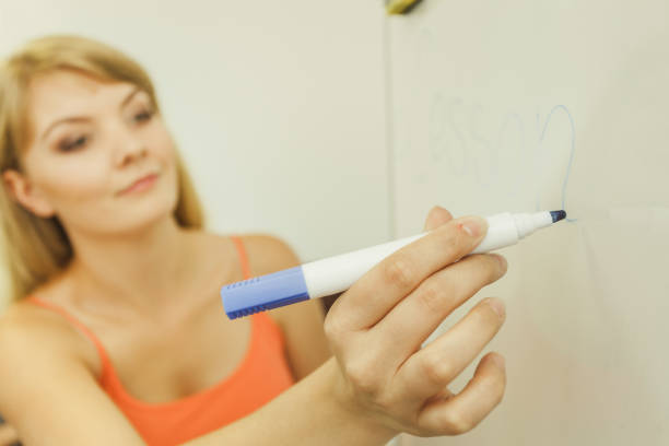 istock woman with marker writing word lesson on whiteboard 1190391230