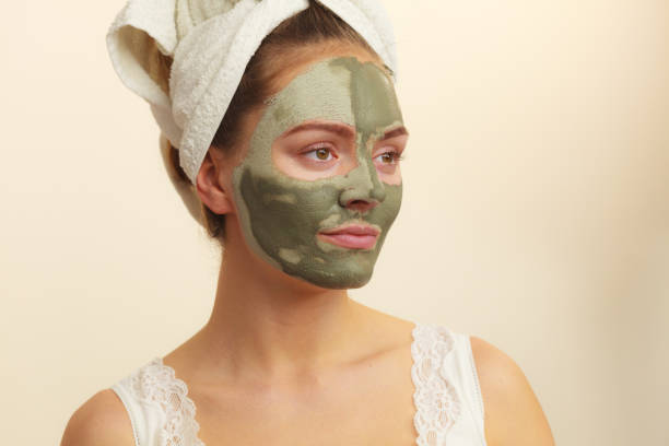 istock Woman face with green clay mud mask 1190391266