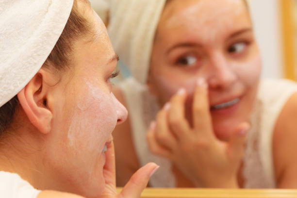 istock Woman applying mask cream on face in bathroom 1190392285