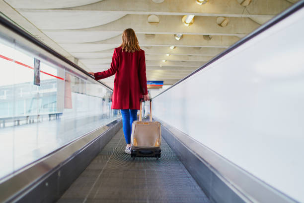 joven cita en el aeropuerto internacional con equipaje - moving walkway fotografías e imágenes de stock