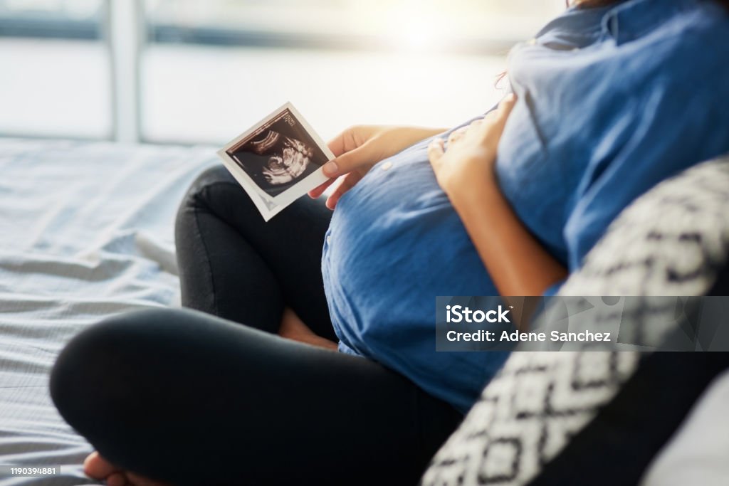 The beginning of a beautiful bond Closeup shot of an unrecognizable pregnant woman holding an ultrasound scan Pregnant Stock Photo