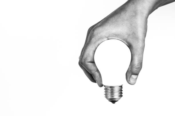 Light Bulb in Hand Light bulb in human hand, b&w. negative space illusion stock pictures, royalty-free photos & images
