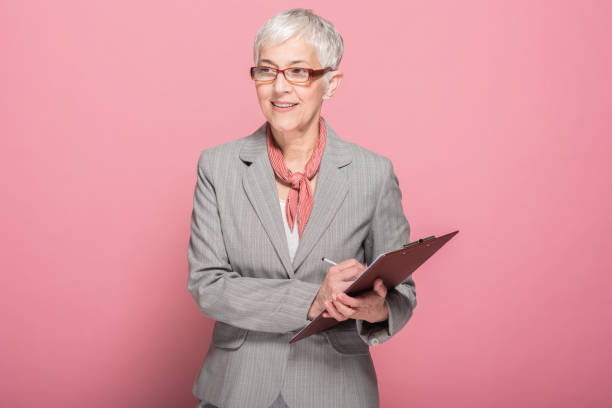 istock Senior businesswoman writing down in a document 1190402048
